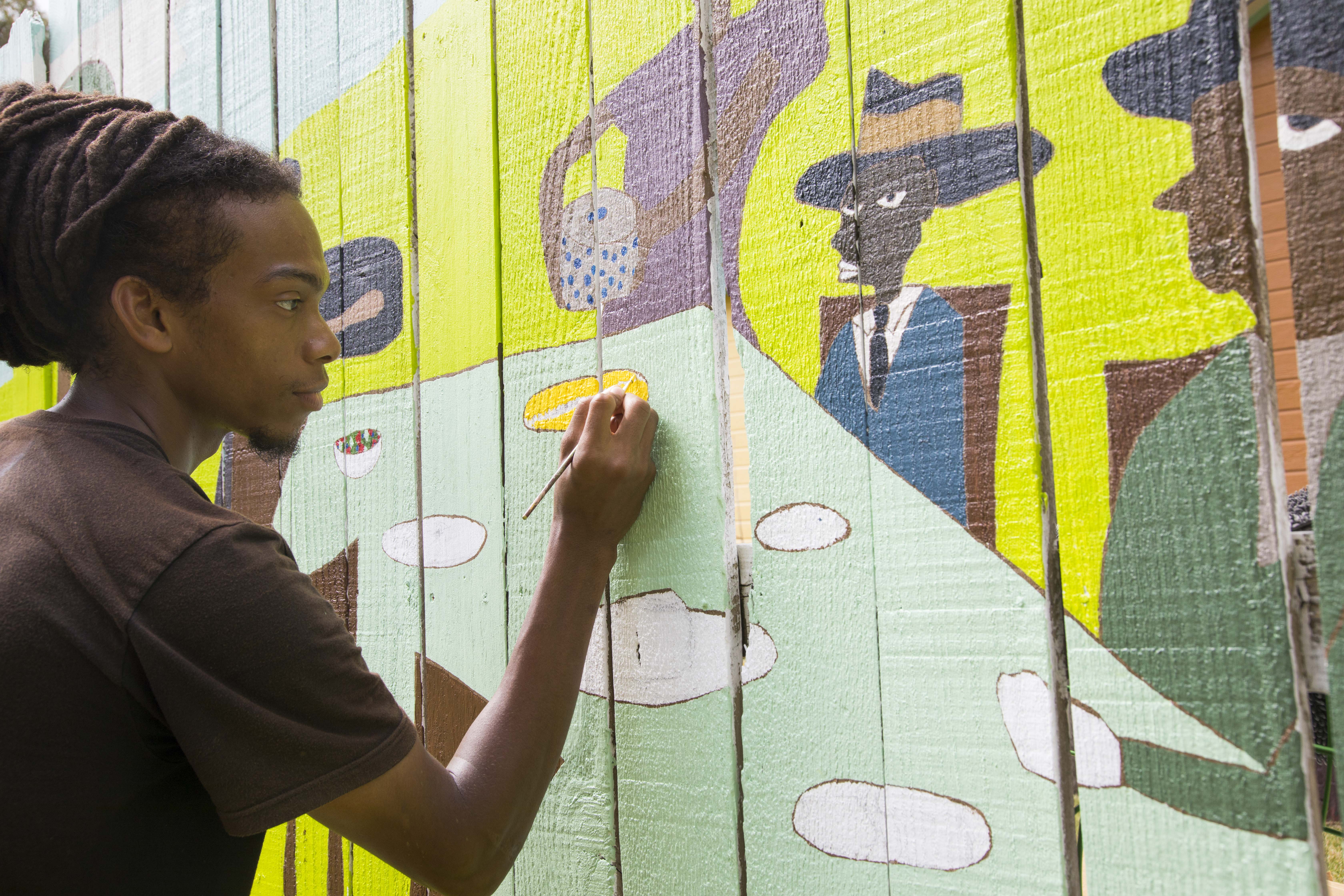 Local resident artist Hotep finishes 40' mural in the Grenada Street Folk Garden!